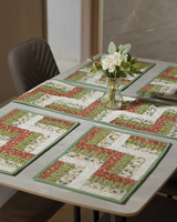 A beautifully set dining table showcasing the Zigzag Lattice & Floral Mosaic runner and mats, styled with a white floral centerpiece to highlight the sage-green accents.