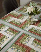 A wide lifestyle shot of the table setting under bright lighting, showcasing the cohesive look of the terracotta and green tones.
