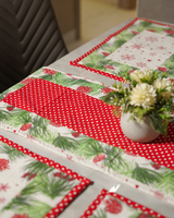 A bird's-eye view of a single place setting, showcasing the vibrant red polka dot border of the mat and the central floral centerpiece.