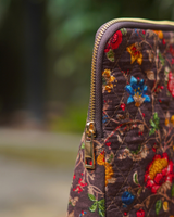 A close-up side view of the bag's upper corner, showcasing the secure brown-toned zipper and the high-quality gold-toned hardware.