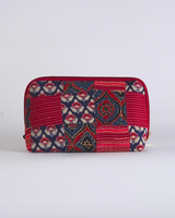 A straightforward horizontal view of the pouch, highlighting the symmetrical arrangement of the hand-quilted panels and the secure crimson-toned zipper.