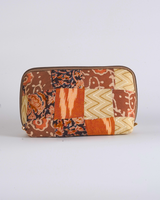 A front-facing studio shot of the Earthy Rust & Ochre Quilted Pouch, showcasing its intricate patchwork of warm terracotta, orange, and tan textile blocks.