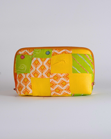 A straightforward horizontal view of the pouch against a white background, highlighting the symmetrical quilting and the orange-toned zipper closure.