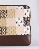 A side-angle shot of the laptop bag, showcasing the sturdy dark brown base and the gold-toned zipper hardware.