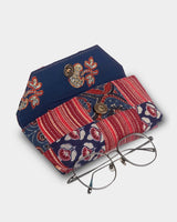 An angled shot from above showing the case open with eyeglasses resting on the flap, emphasizing the 3" width and the high-quality quilted texture.