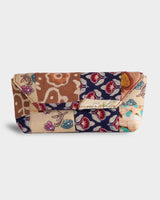 A front-facing studio shot of the Woven Floral Eyewear Case, showcasing its structured, rounded silhouette and a tapestry-inspired patchwork of cream, navy, and tan floral blocks.