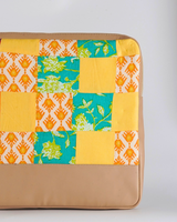 A full vertical shot of the laptop bag, showcasing the intricate hand-quilted texture and the slim, protective design of the tech sleeve.