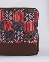 A close-up of the laptop bag’s lower half, showcasing the contrast between the detailed quilted fabric and the smooth, protective tan base.