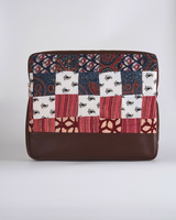 A front-facing studio shot of the laptop bag, highlighting the diverse botanical and geometric prints within the quilted block pattern.