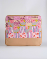 A Back-facing view of the pink and lilac patchwork laptop bag, highlighting the artisanal hand-quilted texture and the balanced arrangement of the colorful textile panels.