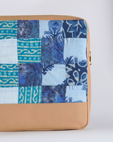 A vertical view of the quilted laptop bag showing its slim, structured profile and the contrast between the artisanal batik fabric and the tan base.