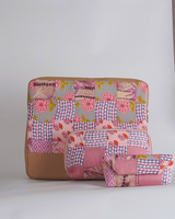 A three-piece coordinated set of quilted tech and utility accessories featuring a pink, lilac, and grey floral patchwork design. The set includes a large laptop bag, a medium utility pouch, and a small eyewear case, all with a smooth tan-toned base.