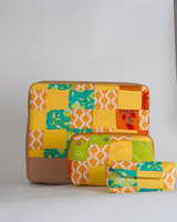 A coordinated three-piece set of quilted tech accessories including a laptop bag, utility pouch, and eyewear case. The items feature a vibrant patchwork of marigold yellow, turquoise, and lime green with a tan base.