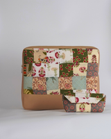 A coordinated two-piece set of handcrafted quilted accessories featuring a laptop bag and a matching structured eyewear case. The design showcases a nature-inspired patchwork of sage green, forest green, and terracotta floral prints with a smooth tan base.
