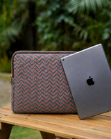 The Teal & Terracotta Zigzag Quilted iPad Sleeve standing on a wooden table next to a grey iPad.