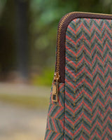 Close-up of the gold-toned metal zipper and the dark brown trim against the intricate zigzag quilting.