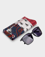 The Heritage Block Quilt Eyewear Case shown alongside a pair of sunglasses, illustrating its practical size and handcrafted elegance as a protective accessory.