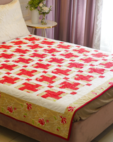 A wide lifestyle shot of the bed under natural light, highlighting the vibrant crimson tones and the structured, symmetrical patchwork.