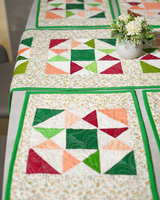 A bird's-eye view focusing on the layout of two placemats, showcasing the consistent floral pattern and the crisp green piping.